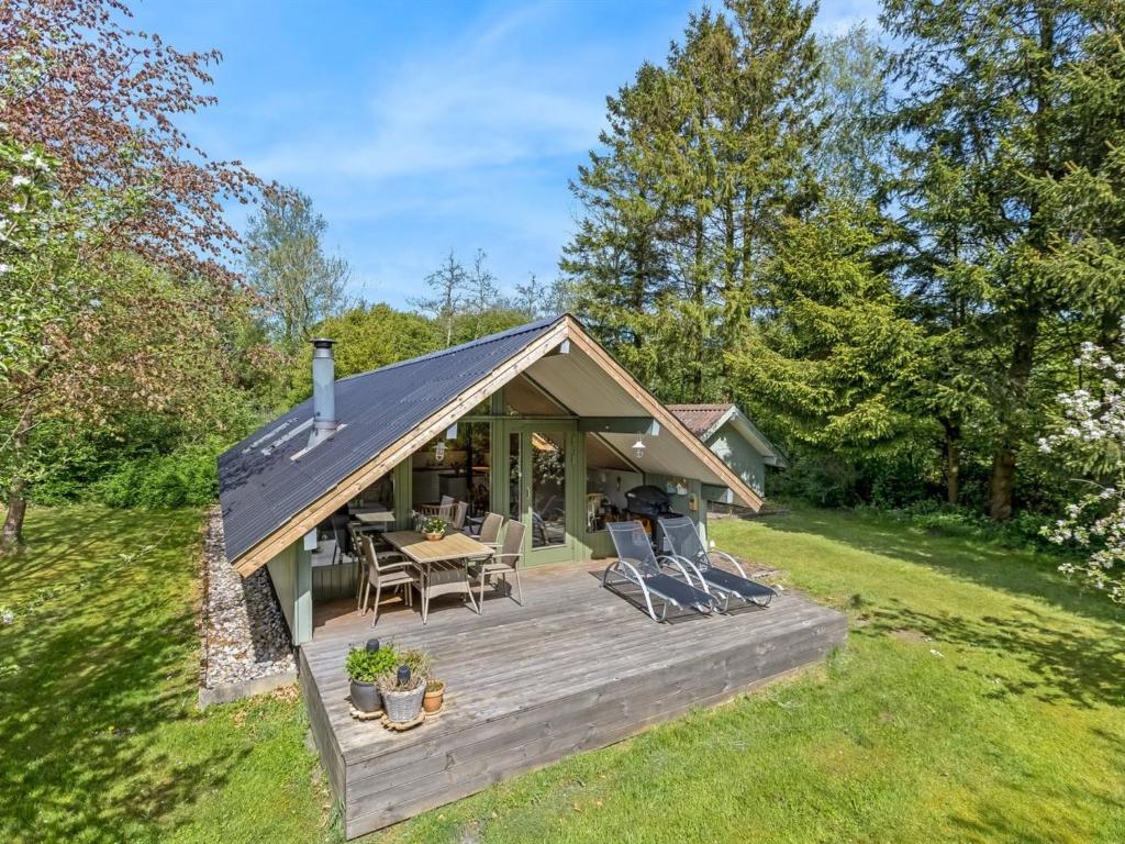 a cabin with a wooden deck in the grass at Holiday Home Hilla - 31km from the sea by Interhome in Toftlund