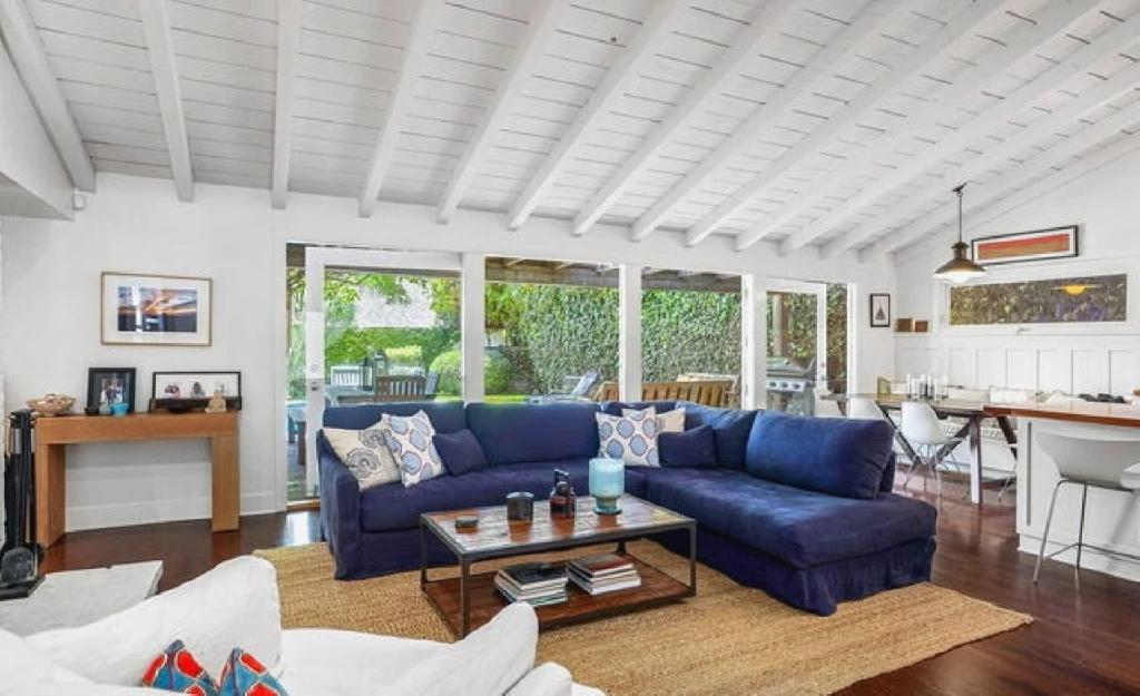 Una sala de estar con un sofá azul y una mesa. en Superb Three Bedroom Home in Santa Monica, en Los Ángeles