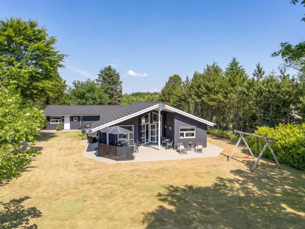 a large house with a playground in the yard at Holiday Home Gylla - 12km from the sea by Interhome in Oksbøl