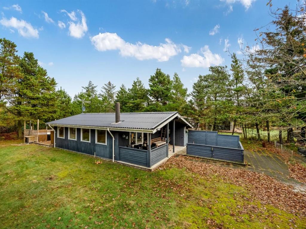 una casa con una casa negra en un patio en Holiday Home Toimi - 500m to the fjord by Interhome, en Ulfborg