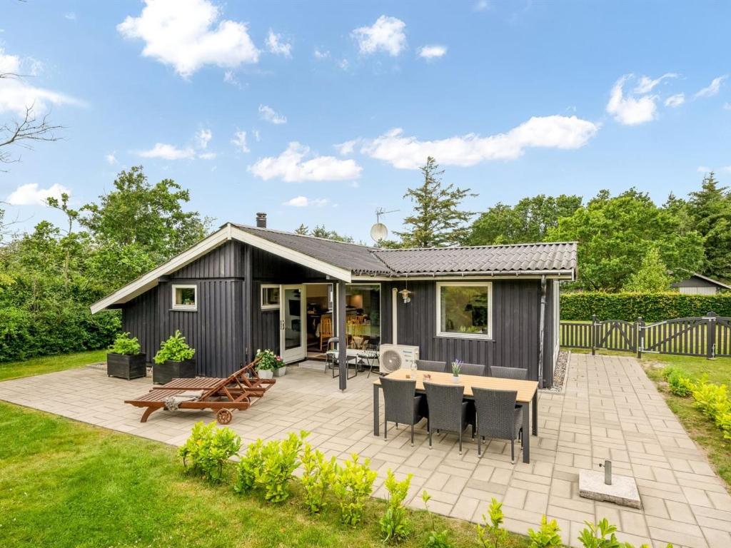 cobertizo negro con patio y mesa en Holiday Home Embla - 500m to the fjord by Interhome, en Ulfborg