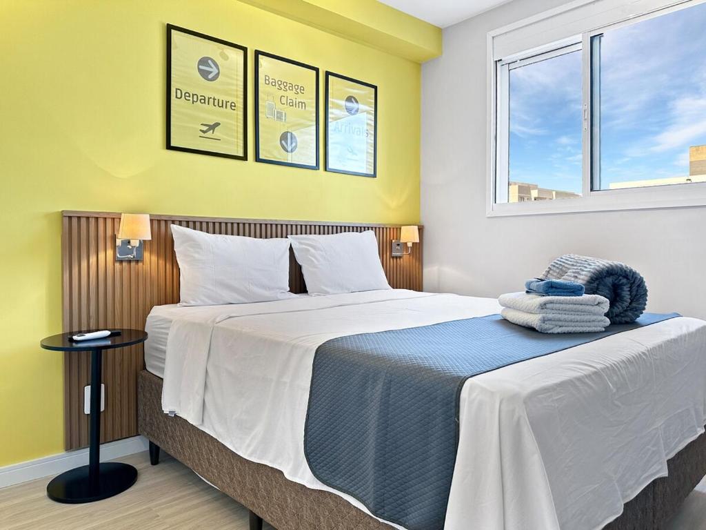a bedroom with a large bed with yellow walls and windows at 2 quartos - AC - Home office - WiFi in Água Boa