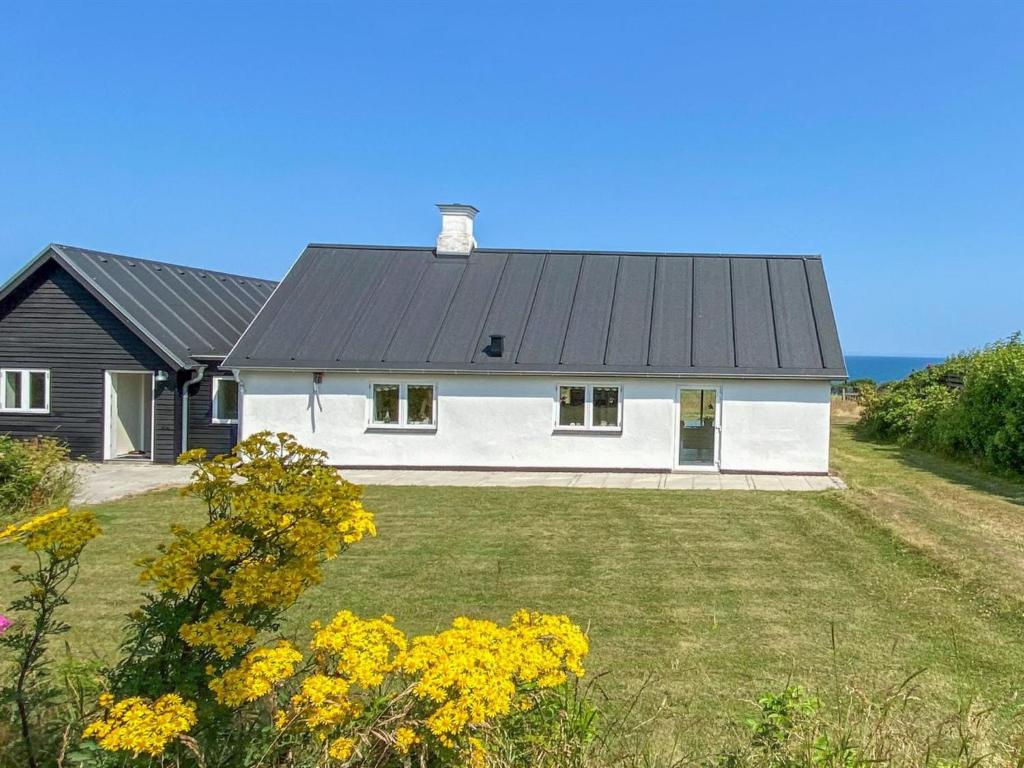 a white house with a black roof and a yard at Holiday Home Alkmar - 75m from the sea by Interhome in Thisted