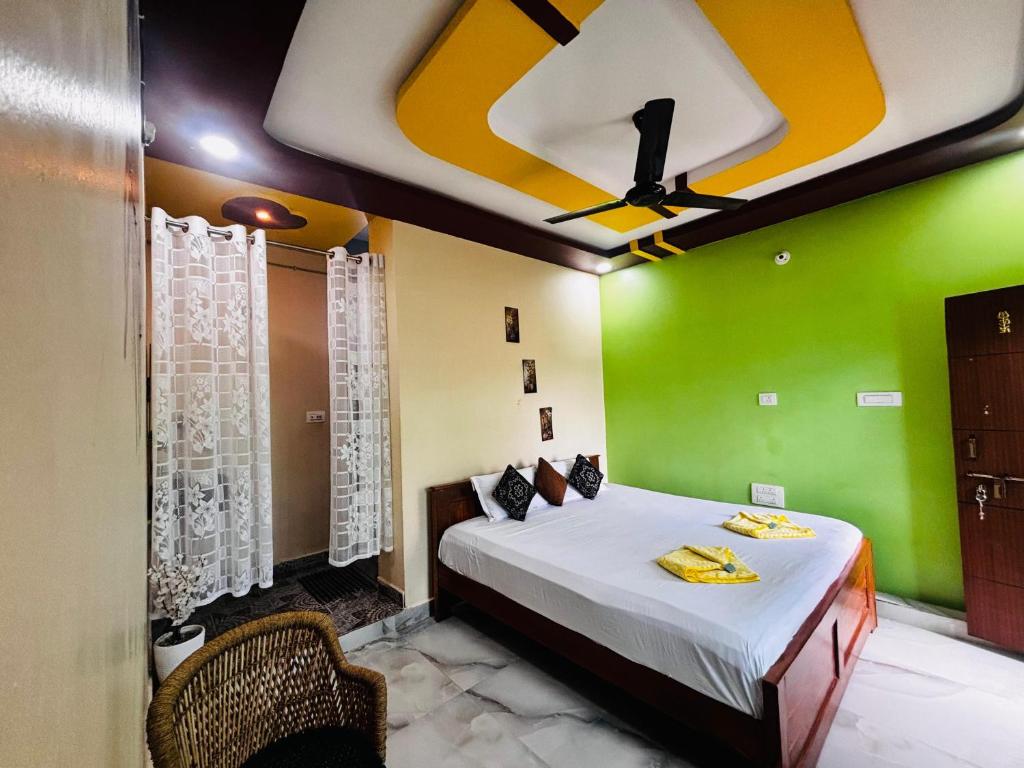 a bedroom with a bed and a green wall at SAHASRA HOME STAY HAMPi in Hospet