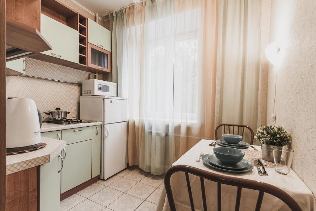 モスクワにあるLakshmi Apartment Alekseevskayaの小さなキッチン(テーブル、椅子、冷蔵庫付)