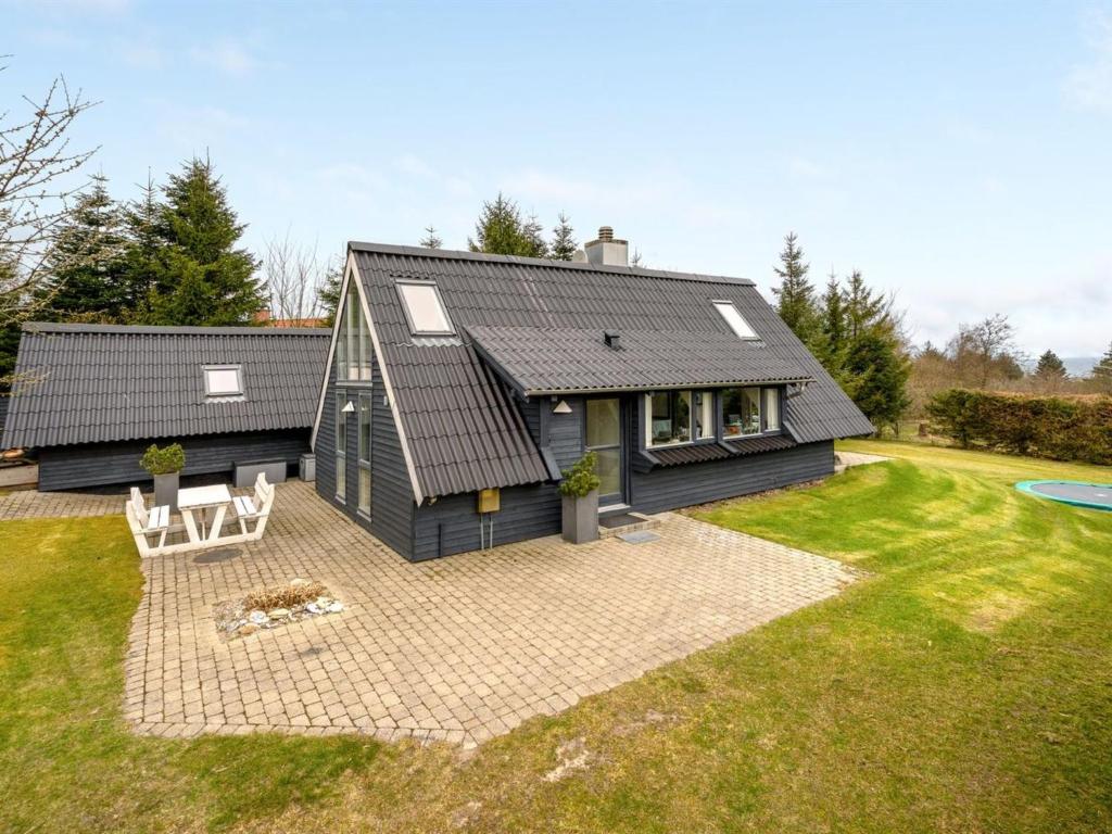 a house with a black roof and a patio at Holiday Home Brunhild - 300m to the inlet by Interhome in Fur