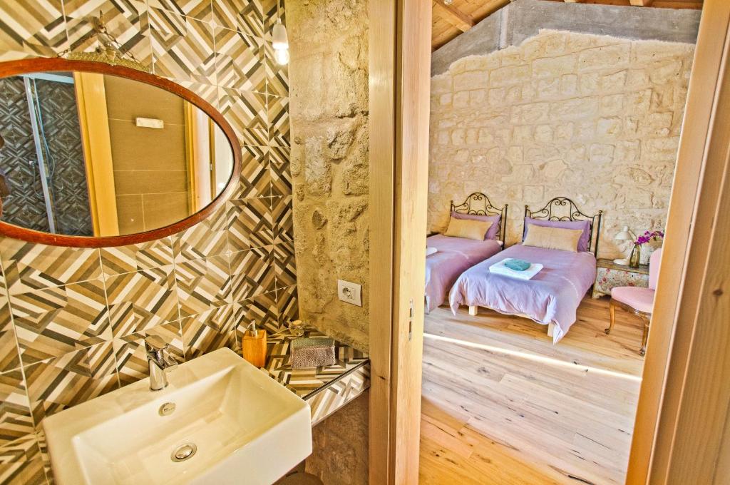 een badkamer met een spiegel en een bed in een kamer bij Agriturismo Pietre di Gelo in Carlentini