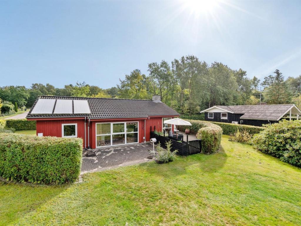 una casa roja con un jardín delante en Holiday Home Anselm by Interhome, en Fårvang