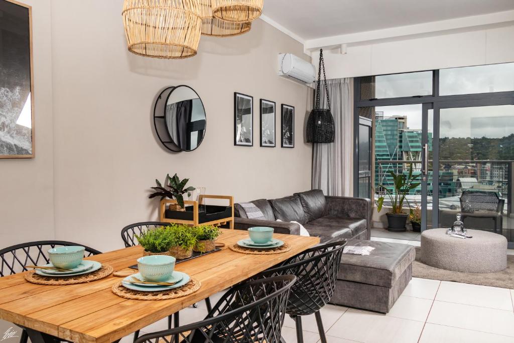 a living room with a wooden table and chairs at Menlyn Maine Luxury Apartments - Penthouse 1217 in Pretoria