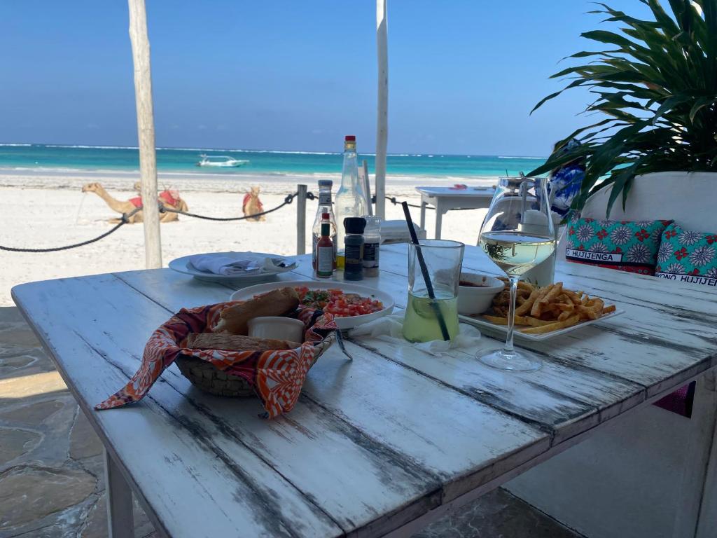 a picnic table with food and wine on the beach at Elegant Double Big Room at Villa Paradise in Diani Beach