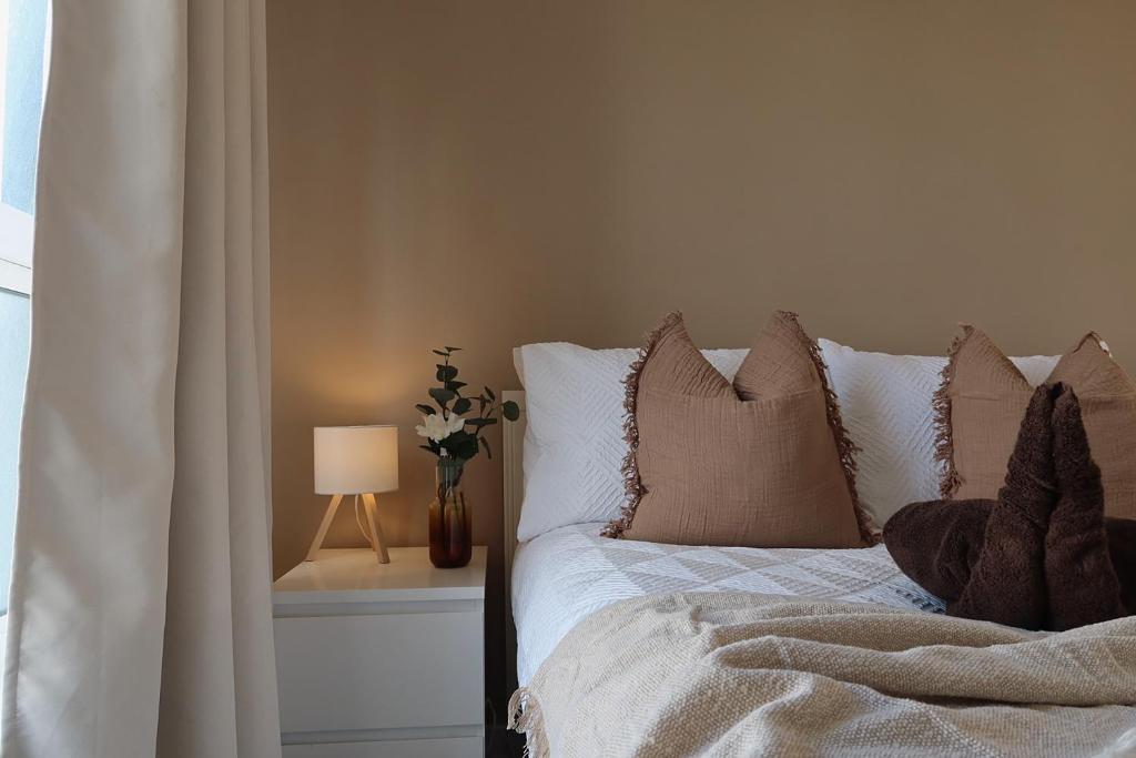 a bedroom with a bed with pillows and a lamp at Newcastle City Centre Apartment with Free Private Parking, Walk Away to Quayside in Newcastle upon Tyne
