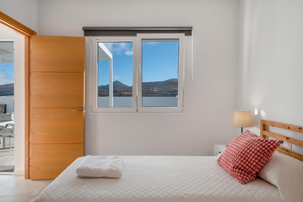 a white bedroom with a bed and a window at Tranquilidad entre volcanes in Uga