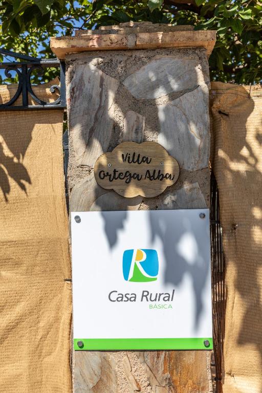 a sign for a building on a stone wall at Villa Ortega Alba in Alcalá la Real