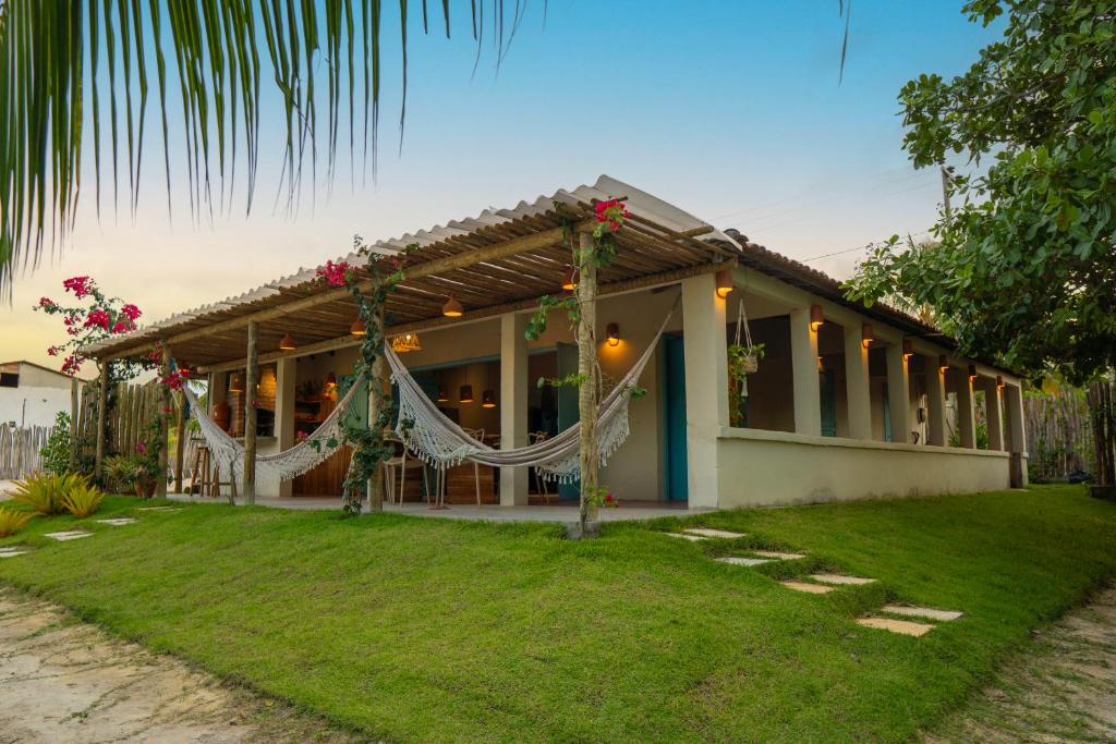 ein Haus mit einer Hängematte davor in der Unterkunft Casa Cajuzal Carrapateira in Acaraú