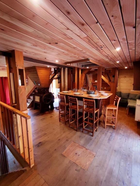 a room with a large wooden table and chairs at Le Moulin de la Hire in Miremont