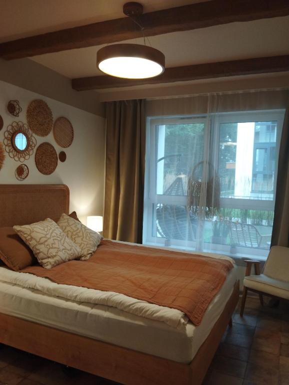 a bedroom with a large bed and a window at Apartament -Podczele in Kołobrzeg