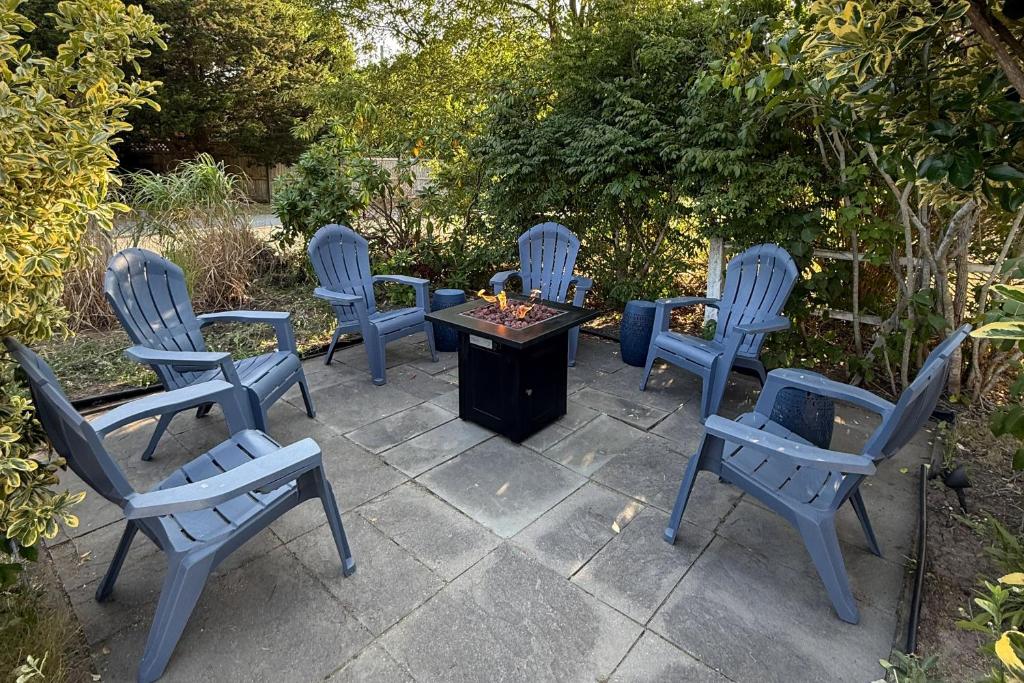a group of blue chairs and a table on a patio at Bocce Court and Outdoor Shower Cape Cod Retreat! in Colonial Acres
