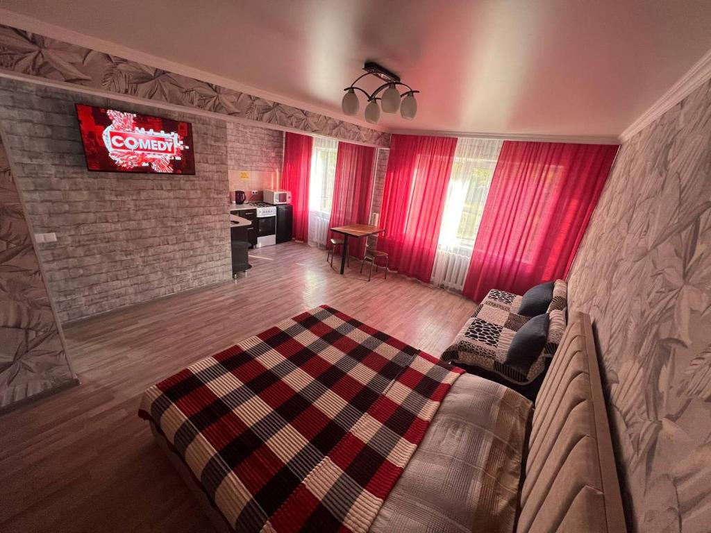 a living room with a couch and a tv at Вип Квартира посуточно in Shakhtīnsk