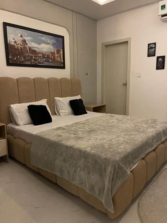 a large bed with two pillows on it in a room at The Greystone Luxe in Rawalpindi