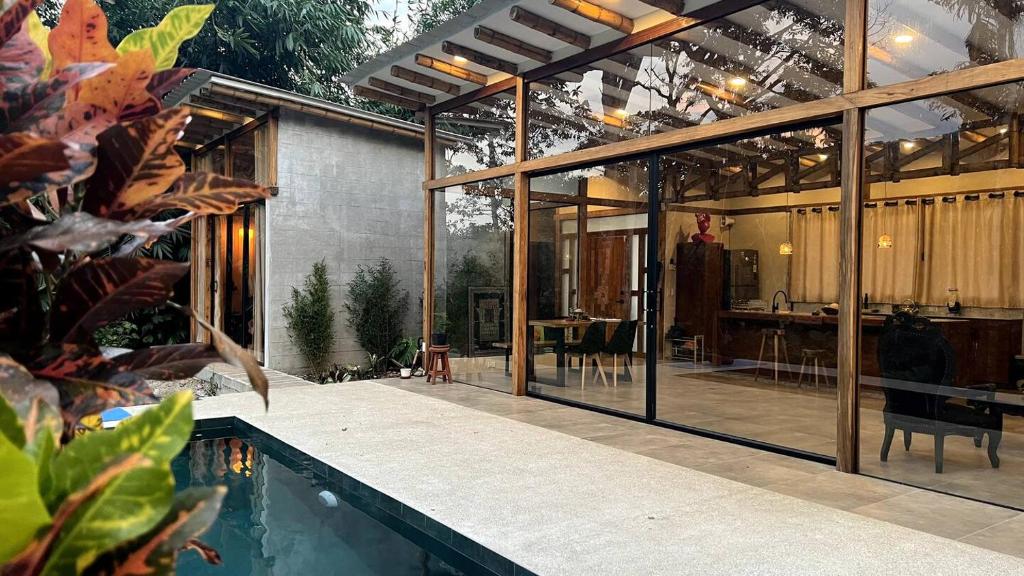 a glass house with a swimming pool and a house at Casa completa con piscina - Casa Dorotea in Macas