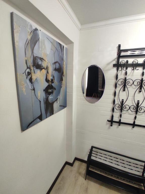 Una habitación con un banco y un espejo en la pared. en Квартира посуточно в Шахтинске, en Shakhtīnsk