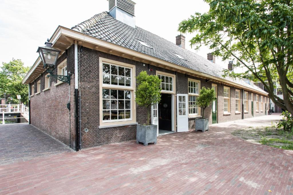 ein Backsteingebäude mit zwei Topfpflanzen davor in der Unterkunft Boutique Hotel d'Oude Morsch in Leiden