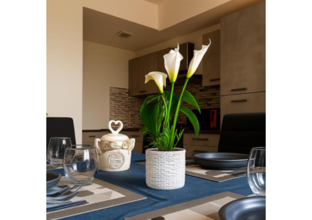 a dining room table with white flowers in a white vase at Chic house in Avezzano