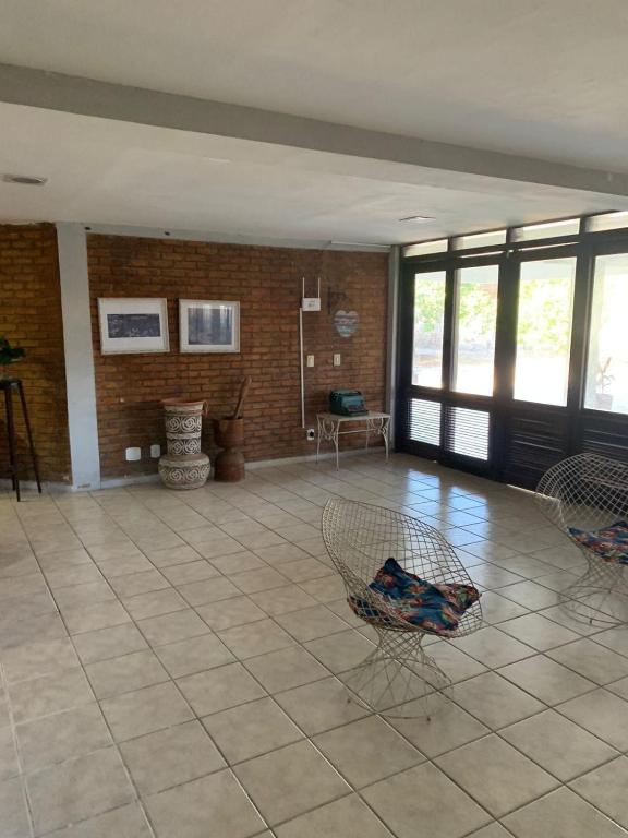 a large room with chairs and a brick wall at Casa de Campo in Eusébio