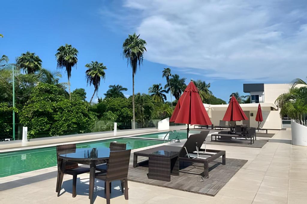 einen Pool mit Tischen, Stühlen und Sonnenschirmen in der Unterkunft 506 Plaza 3.14 by Del Mar in Nuevo Vallarta