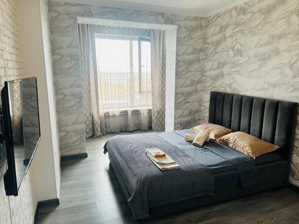 a bedroom with a bed with a stone wall at Аэропорт apartments in Pokrovka