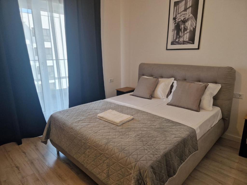 ein Schlafzimmer mit einem großen Bett mit zwei Handtüchern darauf in der Unterkunft Studio Satina Residence with Private Parking & Self Check-In in Craiova