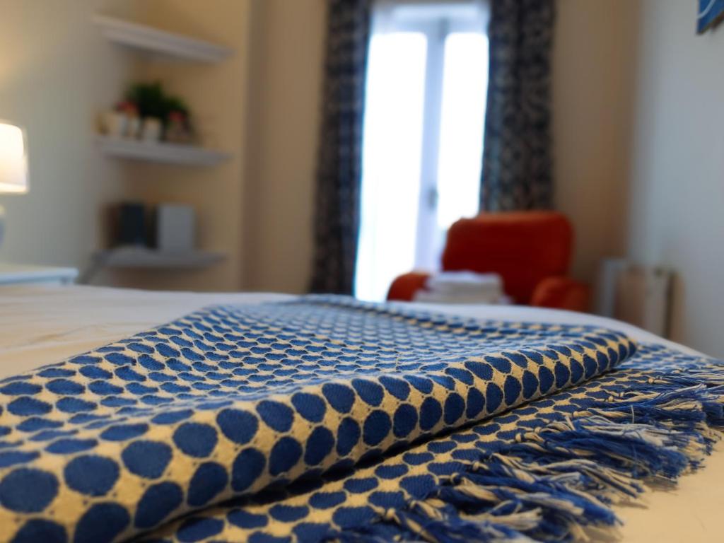 a blue and white blanket sitting on top of a bed at By the River in Glasbury