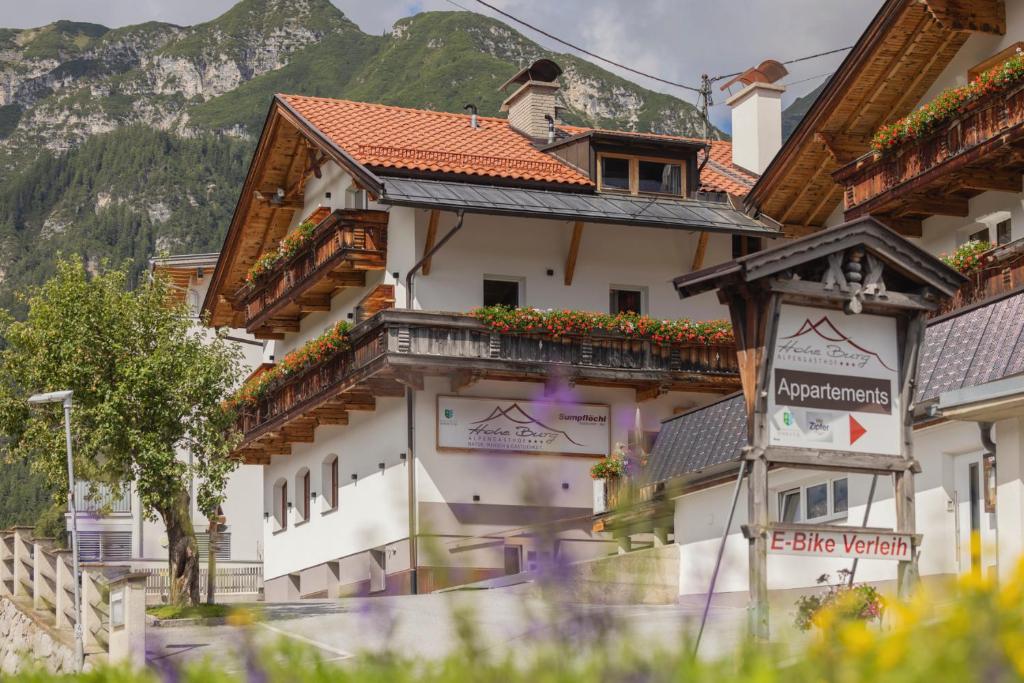 トリンスにあるAlpen Gasthof Apartments Hohe Burgのバルコニーに花が咲く建物