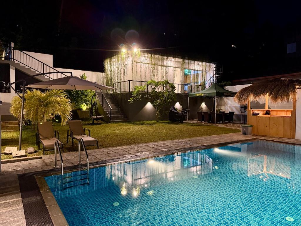 a swimming pool at night with a building in the background at The Bunkyard Galle Hostel in Galle