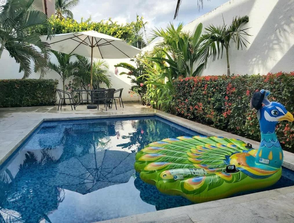 Una piscina con una estatua de pavo real junto a una casa. en Casa Santa Cruz 4 bdrm house-Pool & walk to Beach, en Santa Cruz Huatulco