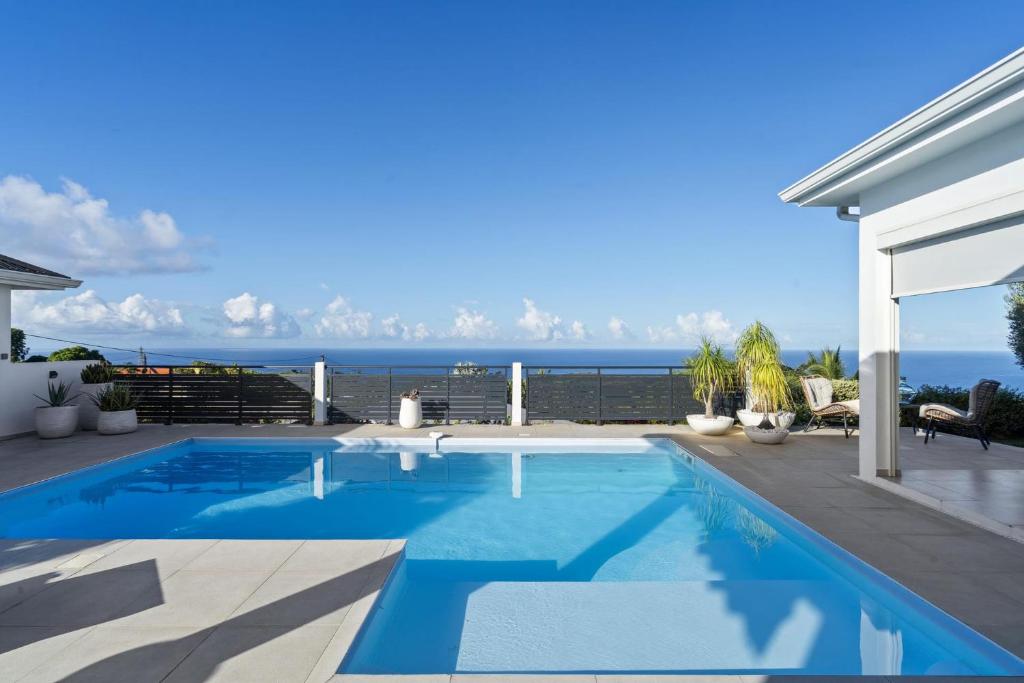 a swimming pool with a view of the ocean at Villa Blanca in Case-Pilote