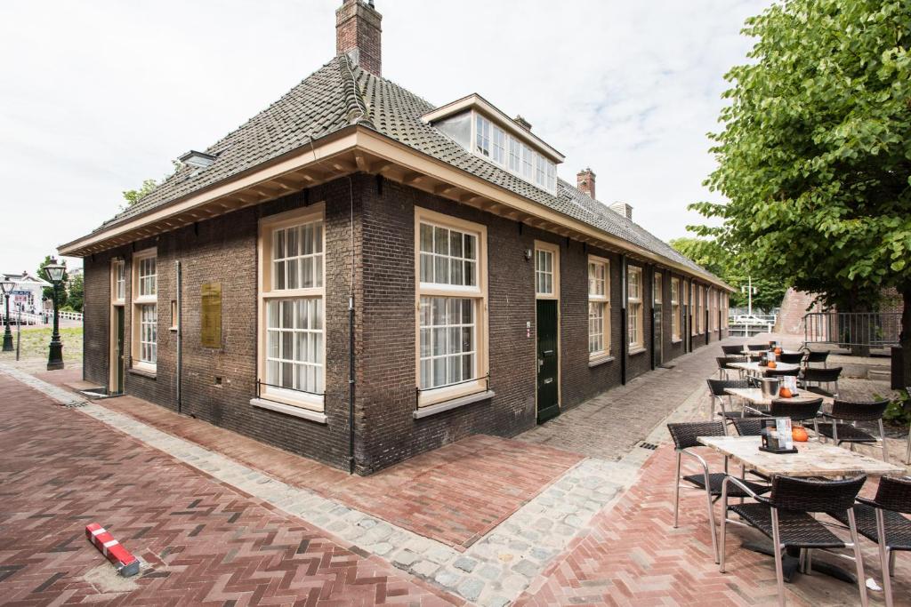 een gebouw met tafels en stoelen ervoor bij Boutique Hotel d'Oude Morsch in Leiden