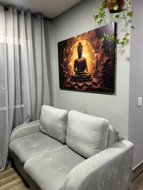 ein Wohnzimmer mit einer Couch und einem Gemälde an der Wand in der Unterkunft Quarto em Apartamento Vila Prudente in São Paulo