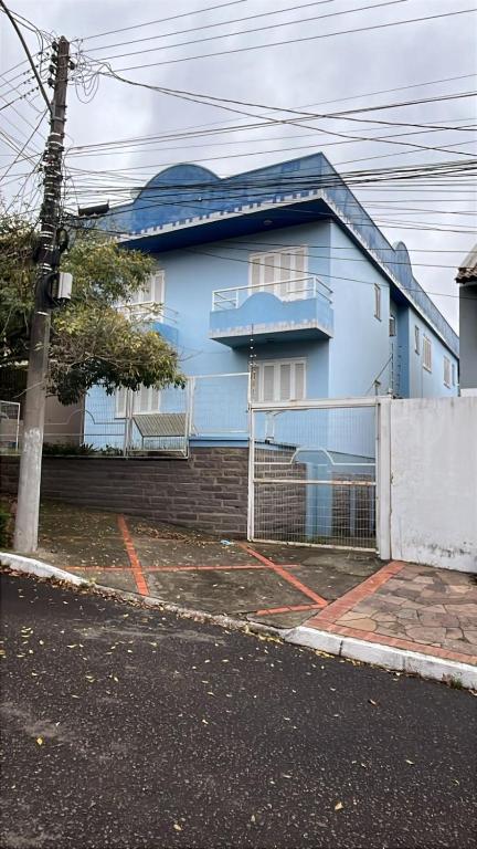 a blue house on the side of a street at Residencial Alfa in Canoas
