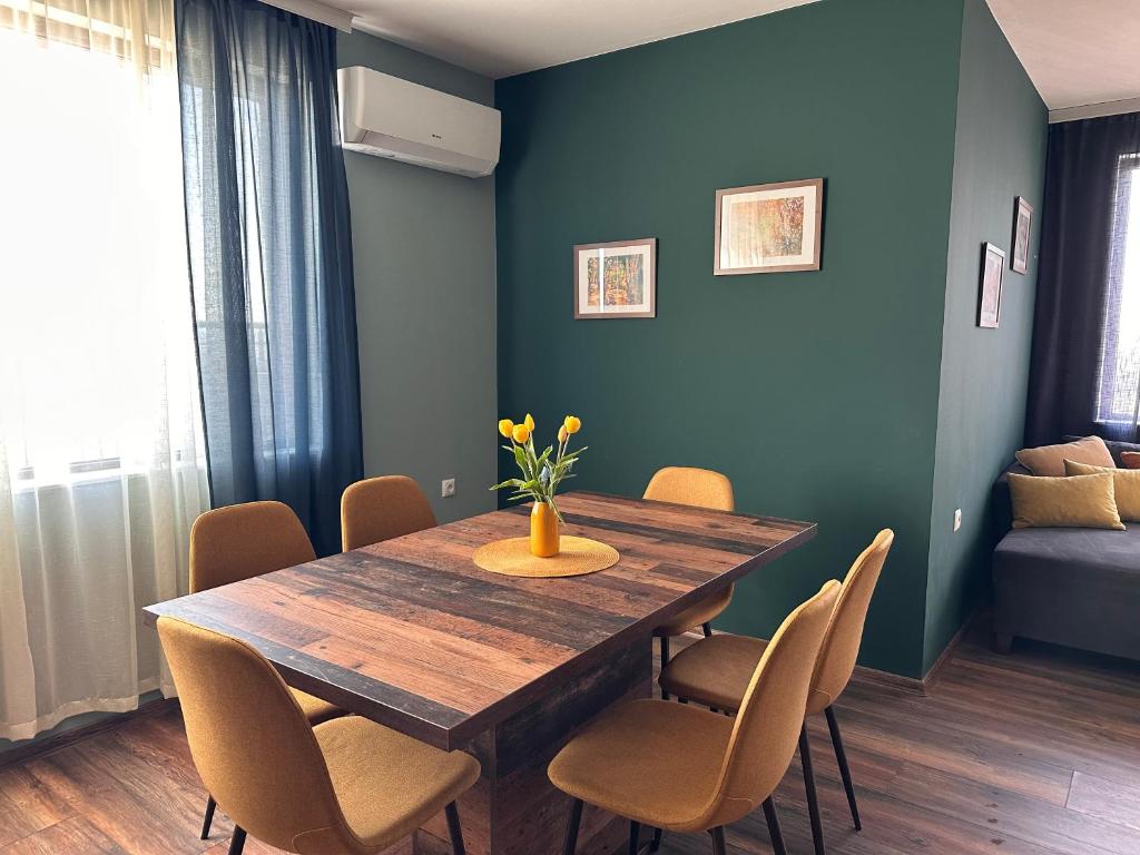 a dining room with a wooden table and chairs at Vyara apartments 56 in Varna City