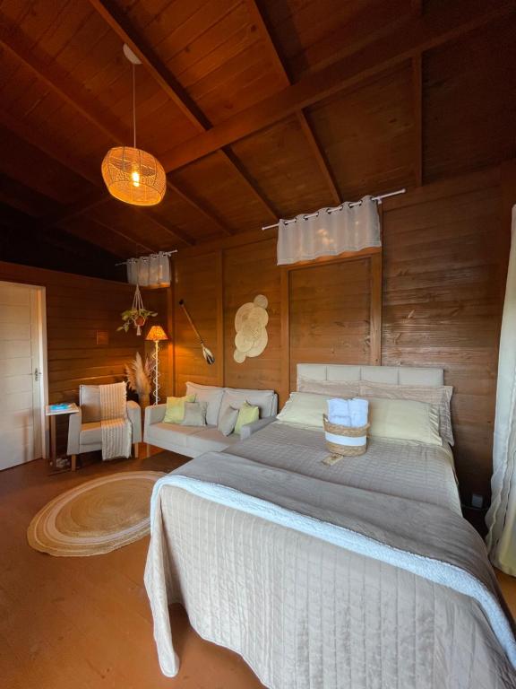 a bedroom with a large bed in a room at Chalé na praia e a beira do Rio Mampituba in Passo De Torres