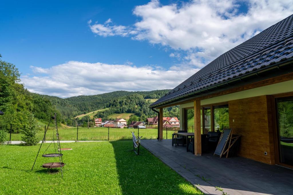 a house with a deck with a view of the mountains at Domek na Duzynie in Ochotnica Górna