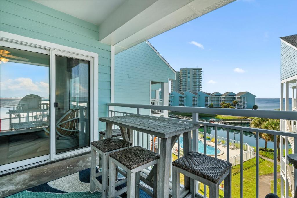 a porch with a table and chairs on a balcony at Baywatch Unit G9 in Pensacola Beach
