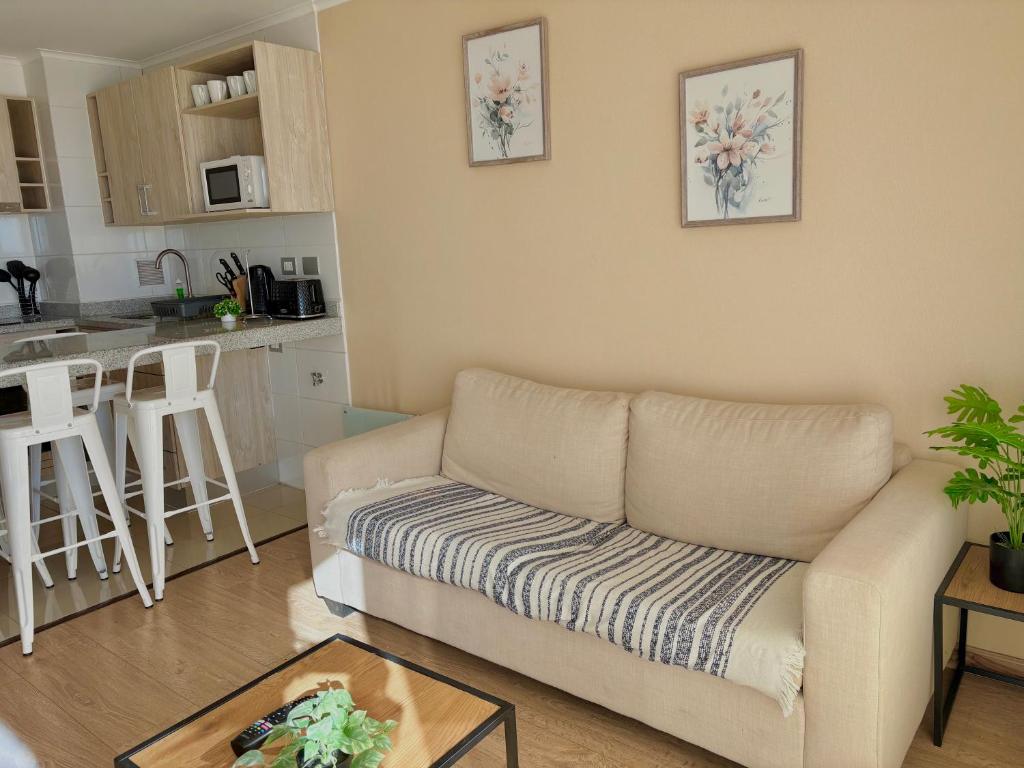 a living room with a couch and a kitchen at Departamento Centro Chillan - Parking -Vista in Chillán