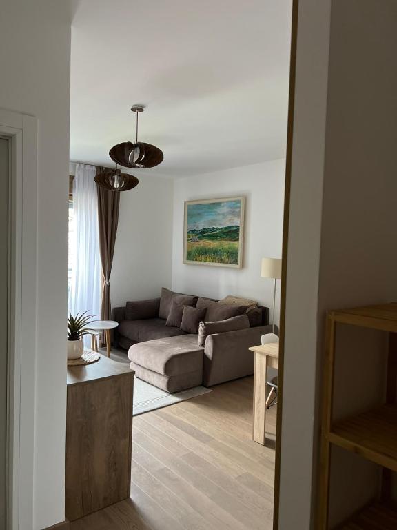 a living room with a couch and a table at Pine & Peak Zlatibor Apartman in Zlatibor