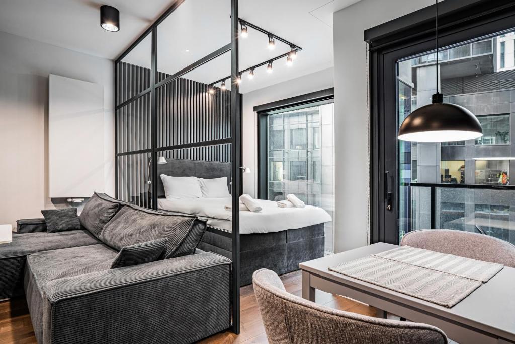 a living room with a couch and a bed at Towarowa Towers Warsaw in Warsaw