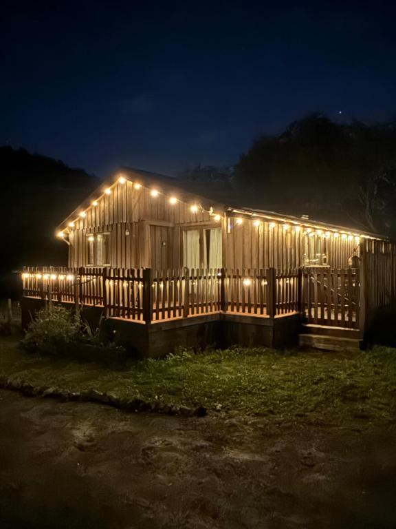 a wooden house with lights on it at night at Glamping Life Retreat in Nantmel