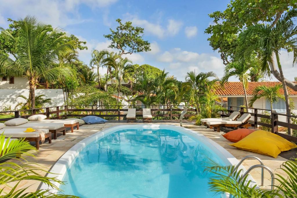 a pool at a resort with tables and chairs at FlowHouse Jeri - Hotel & Coworking in Jericoacoara