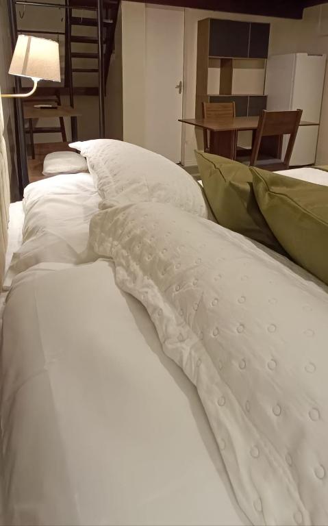 a bed with white sheets and green pillows at Arvore da Vida Pousada in Itaguaí