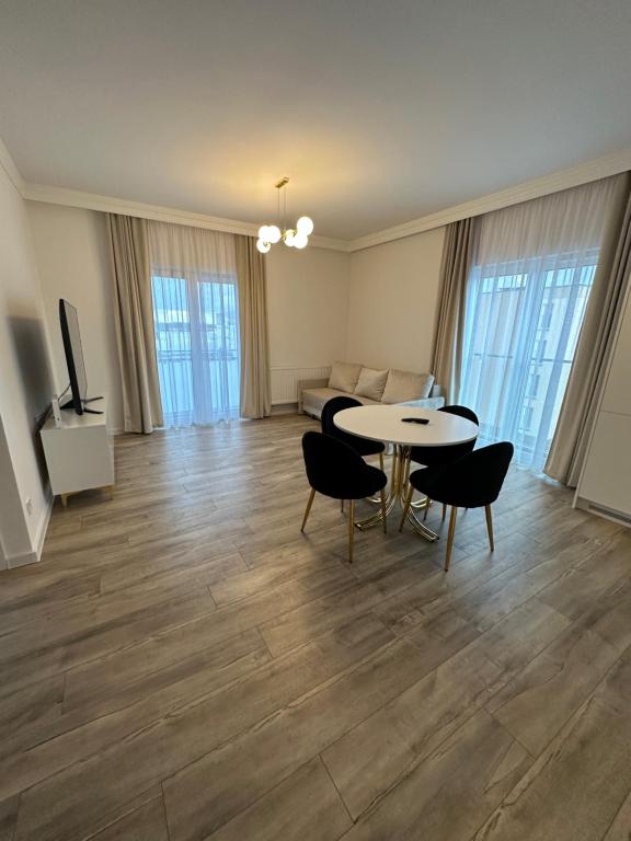 Una sala de estar con una mesa y sillas y un sofá. en Apartament Moniuszki, en Słupca